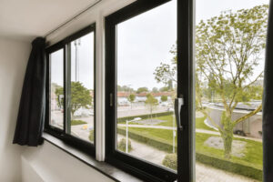 Moderne weiße Kunststofffenster in einem Neubau, mit 3-fach-Verglasung und Blick auf Garten